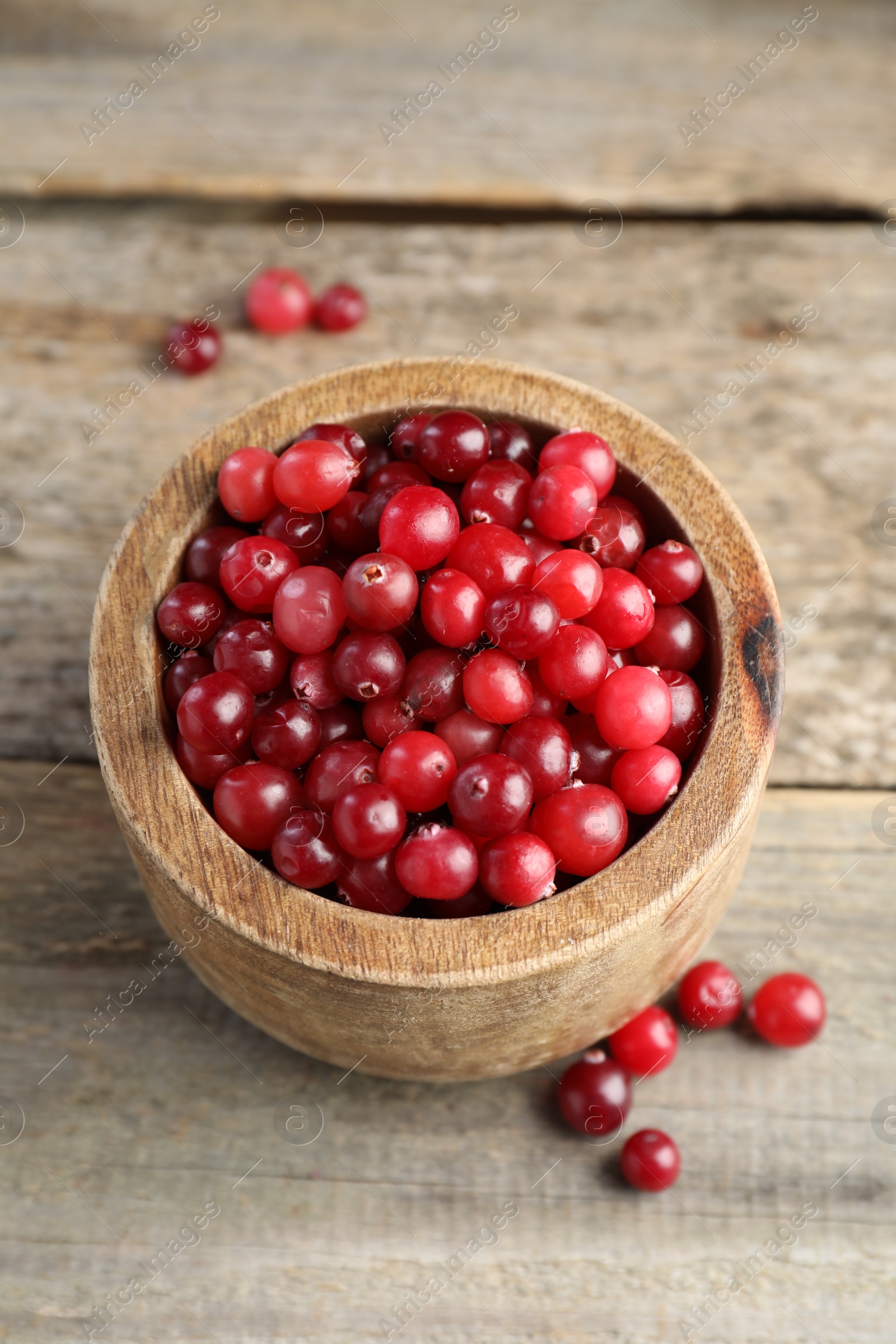 Photo of Cranberries in bowl on wooden table, above view