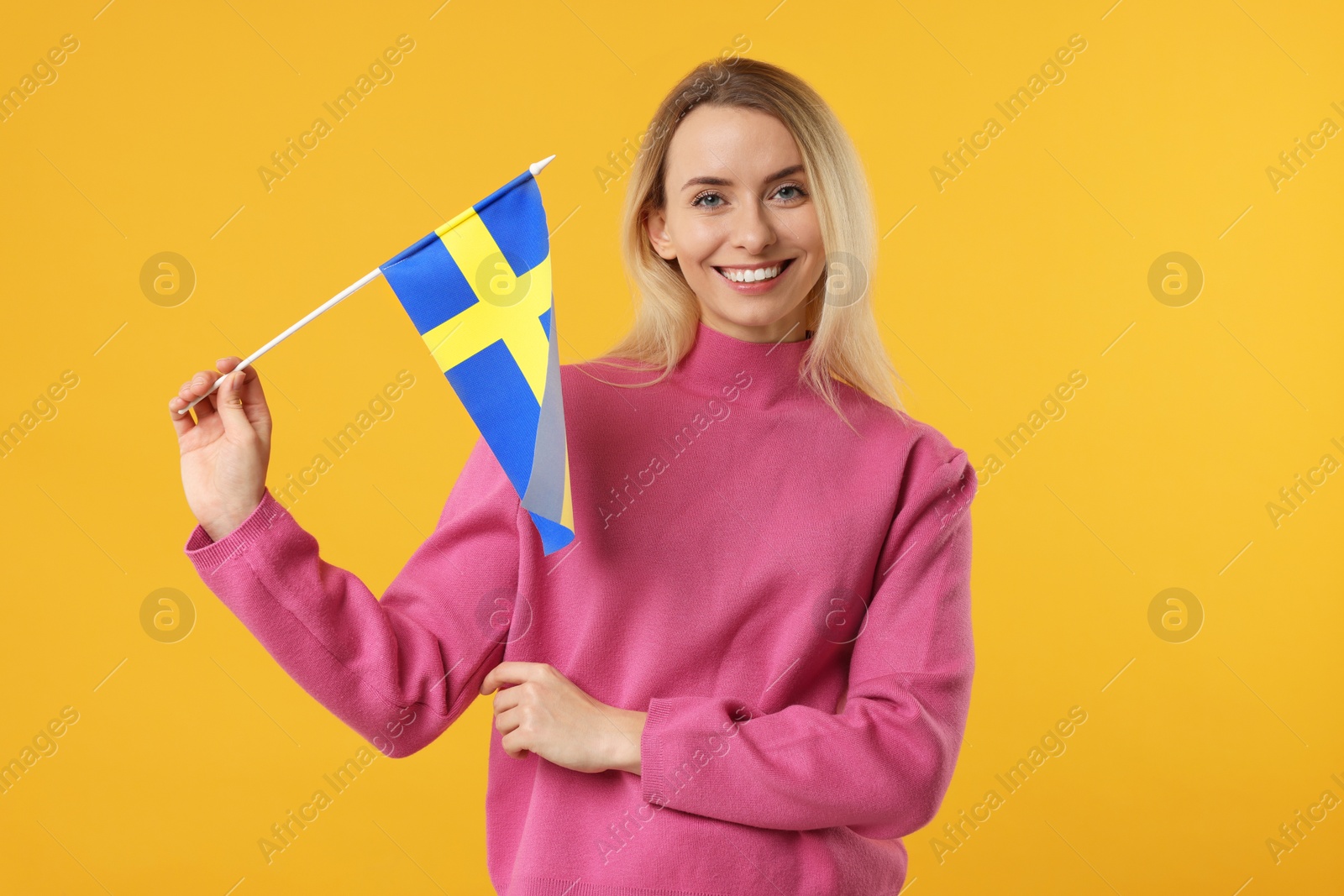 Photo of Happy woman with flag of Sweden on orange background