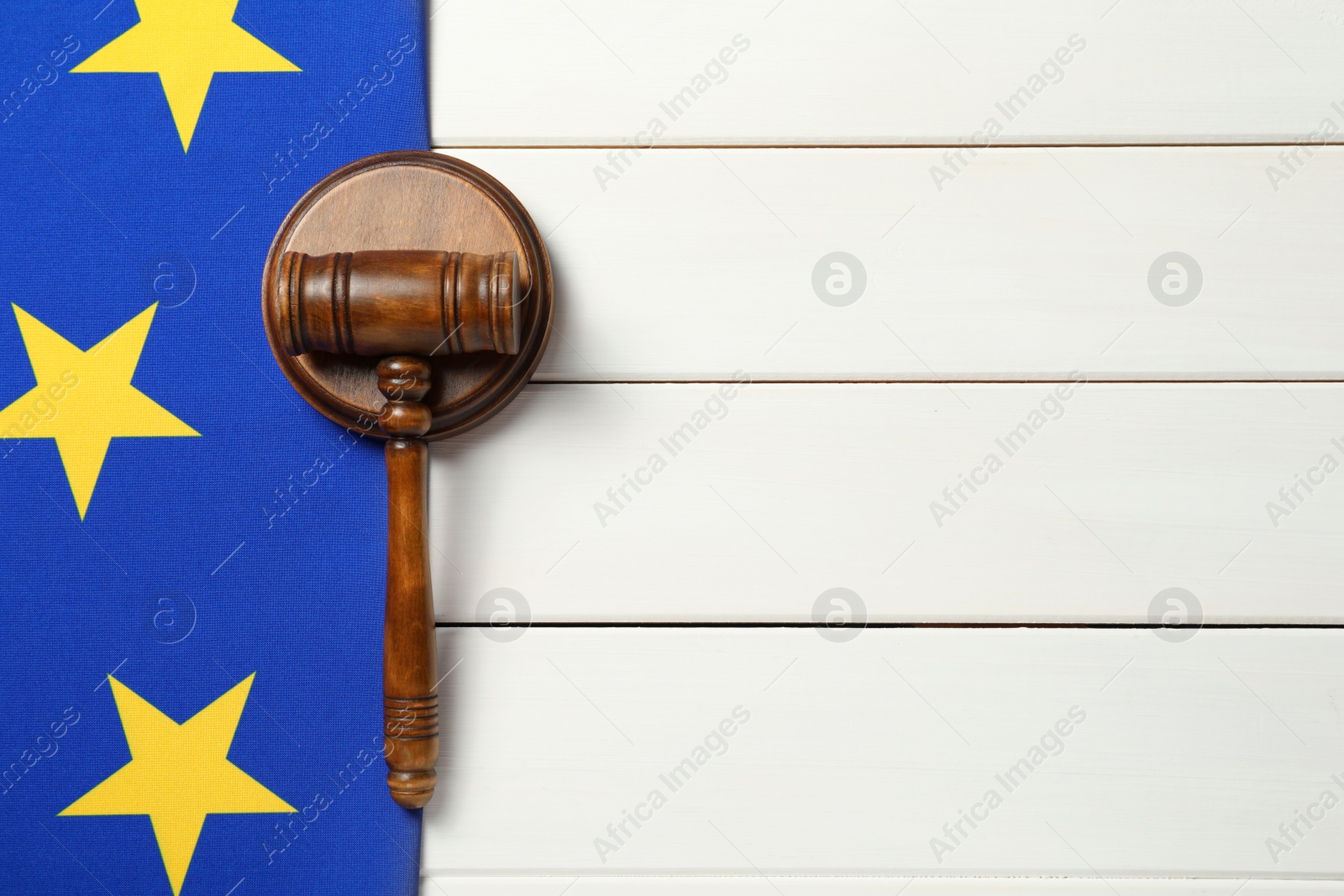 Photo of Judge's gavel and flag of European Union on white wooden table, flat lay. Space for text