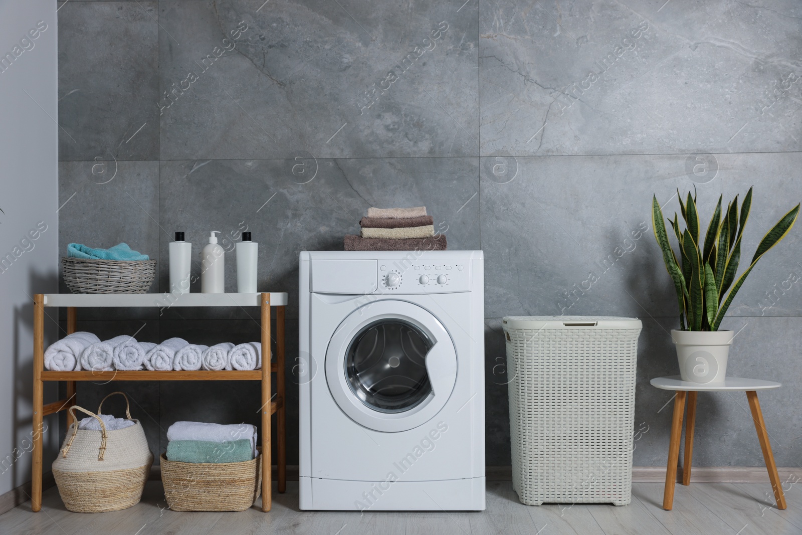 Photo of Many soft terry towels and washing machine in bathroom