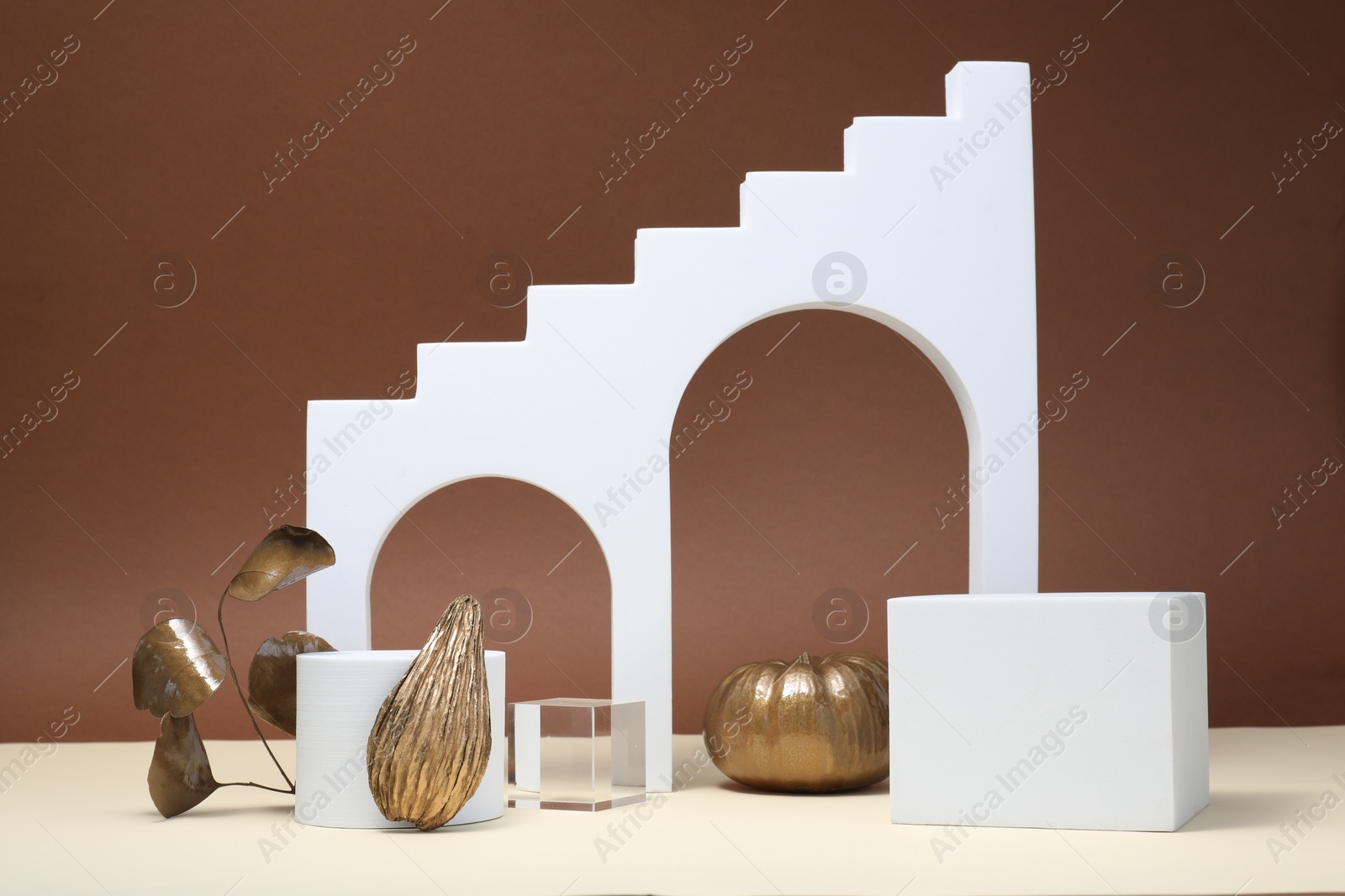 Photo of Autumn presentation for product. Geometric figures and golden decorative elements on brown background