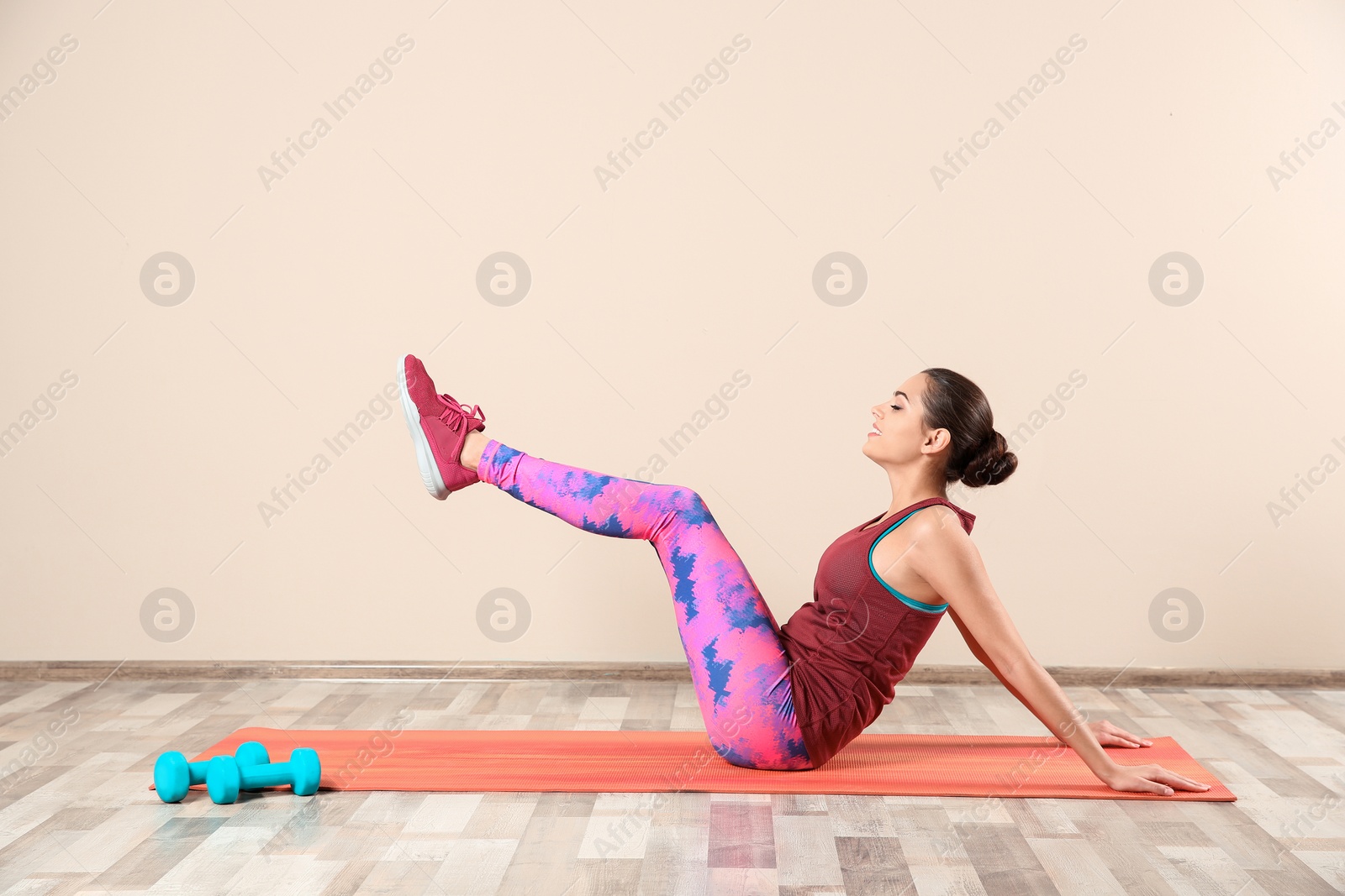 Photo of Young beautiful woman doing exercise at home. Workout and fitness