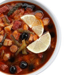 Photo of Meat solyanka soup with sausages, olives and vegetables in bowl isolated on white, top view