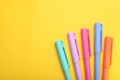 Photo of Many colorful markers on yellow background, flat lay. Space for text