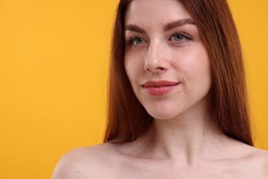 Photo of Portrait of beautiful woman with freckles on yellow background, closeup. Space for text