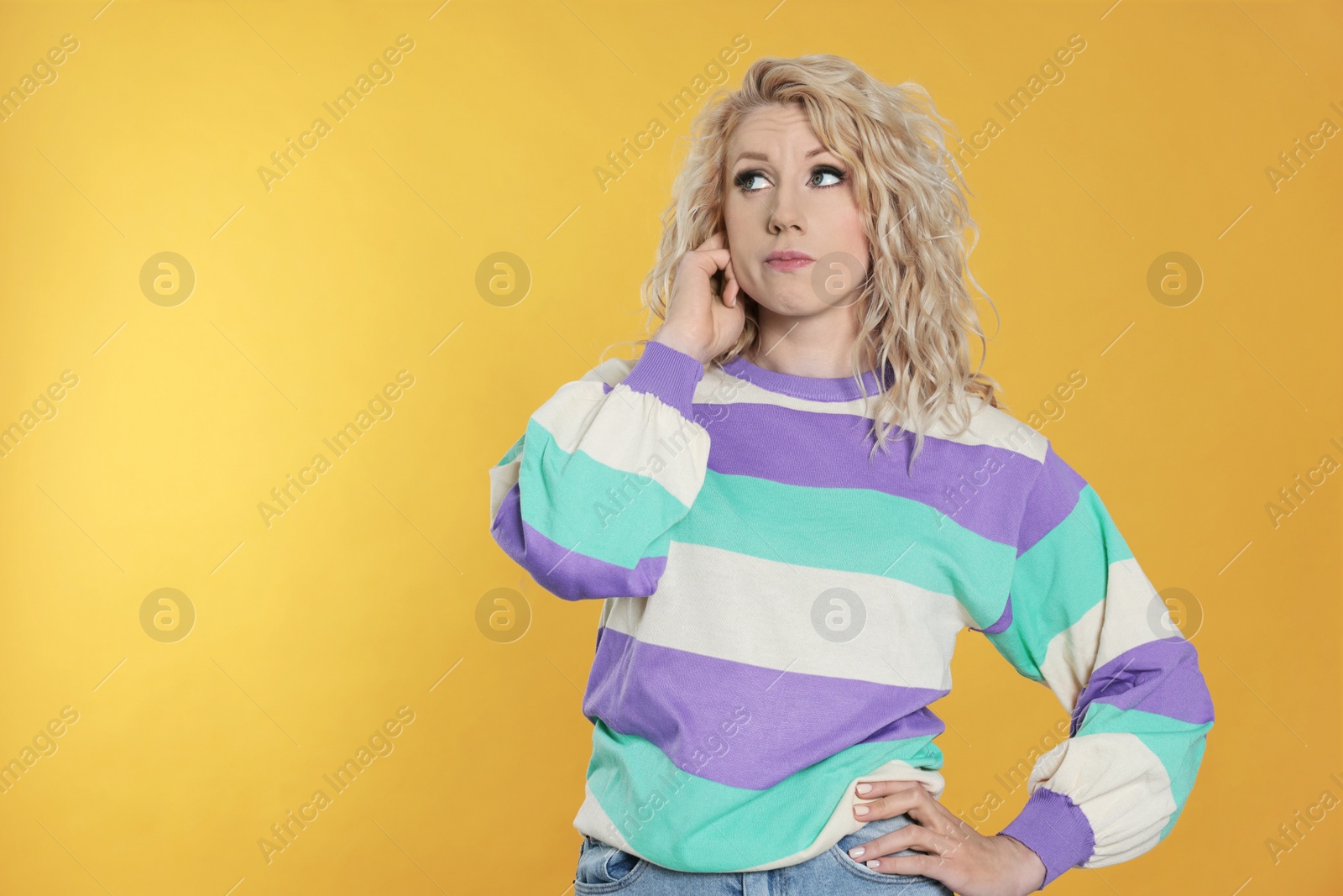 Photo of Portrait of thoughtful young woman on orange background. Space for text