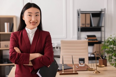 Portrait of smiling notary with crossed arms in office. Space for text