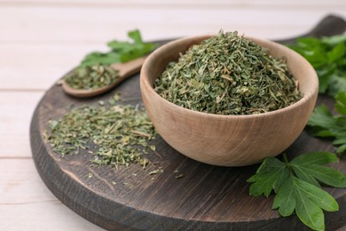 Photo of Dried aromatic parsley and fresh leaves on white wooden table, closeup. Space for text