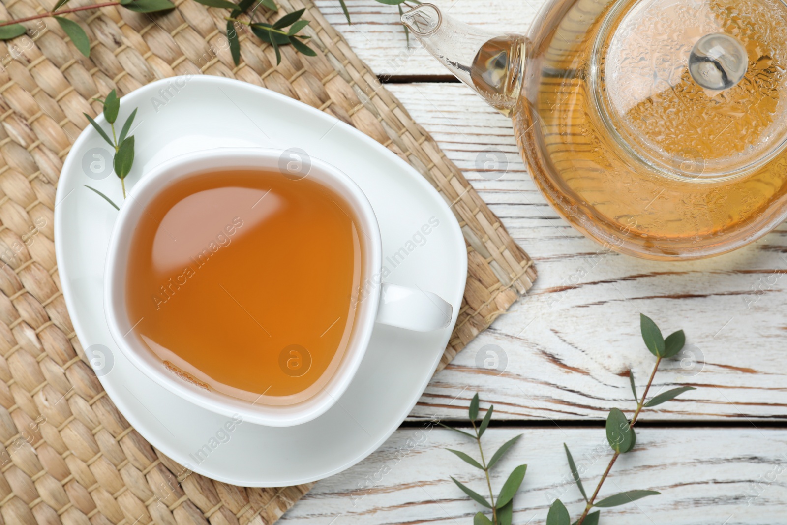 Photo of Aromatic eucalyptus tea on white wooden table, flat lay