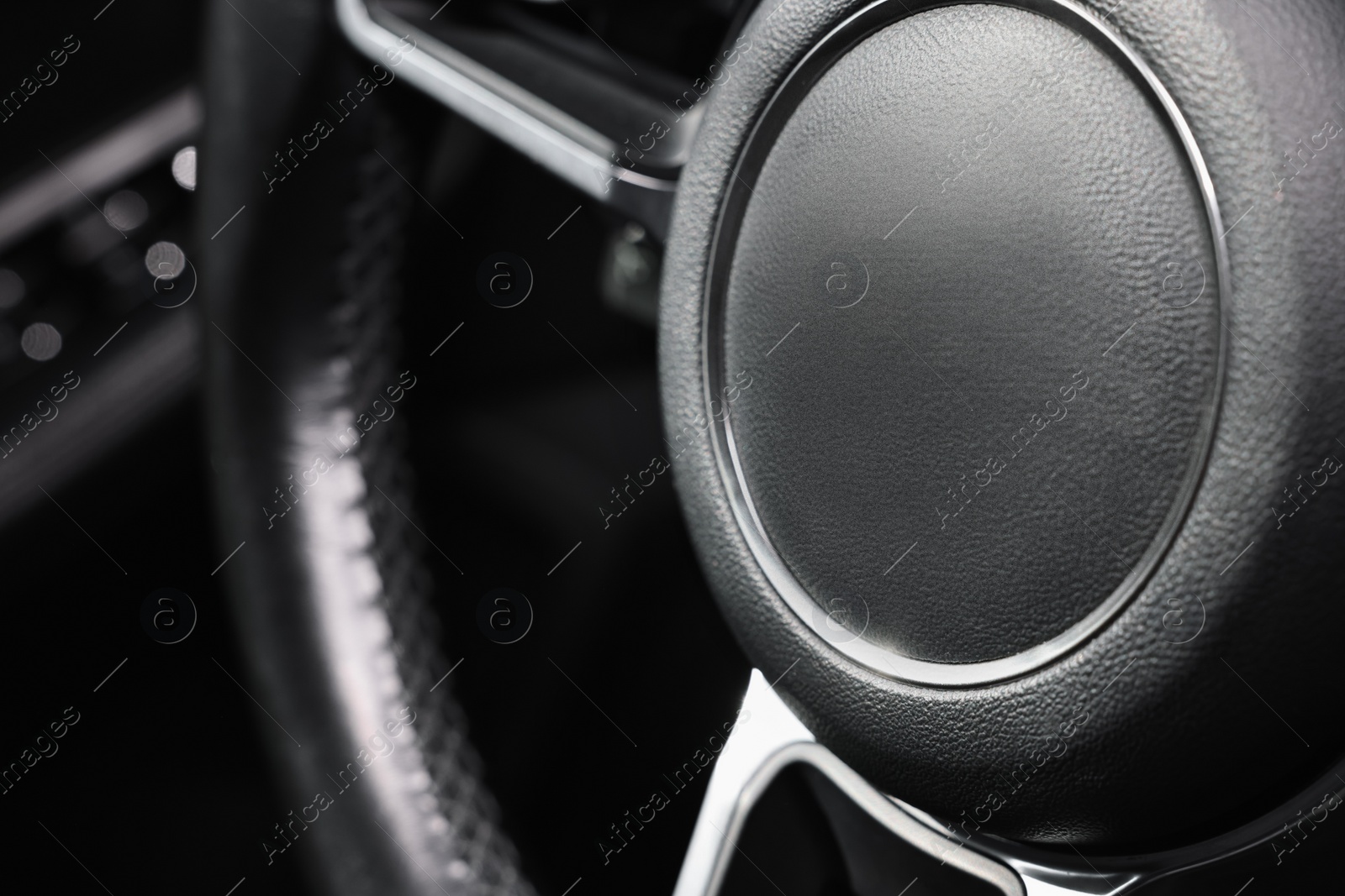 Photo of Steering wheel inside of black modern car, closeup