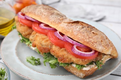 Photo of Delicious sandwich with schnitzel on white wooden table, closeup