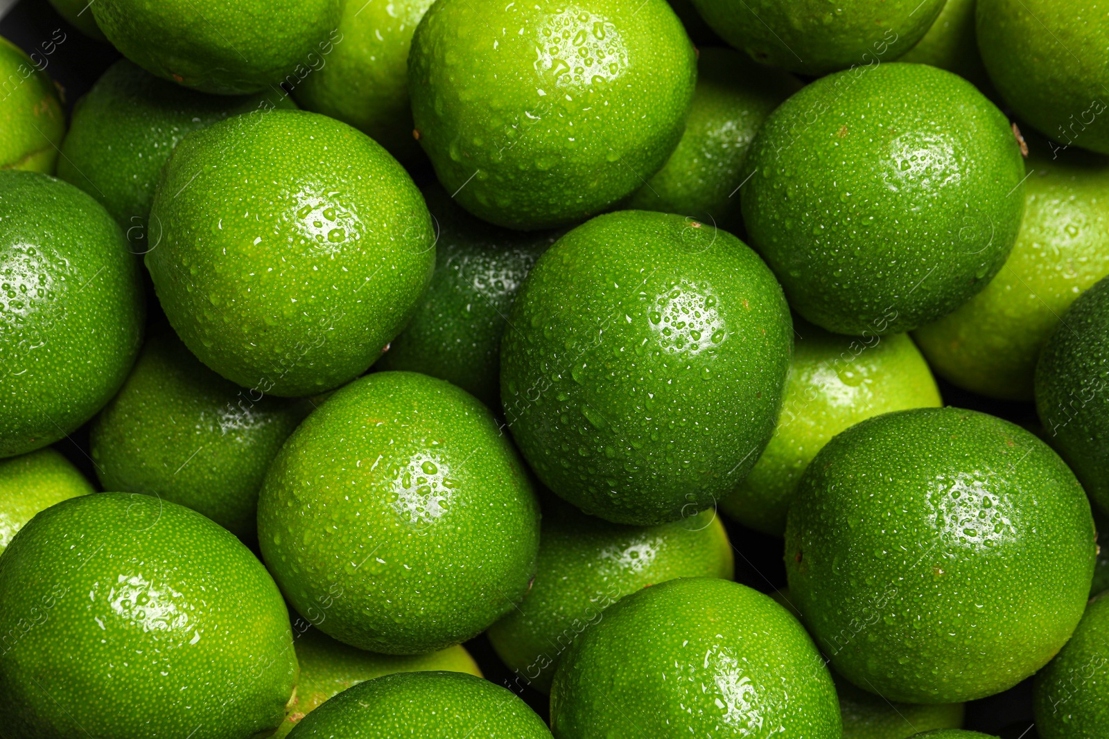 Photo of Fresh ripe limes with water drops as background, top view