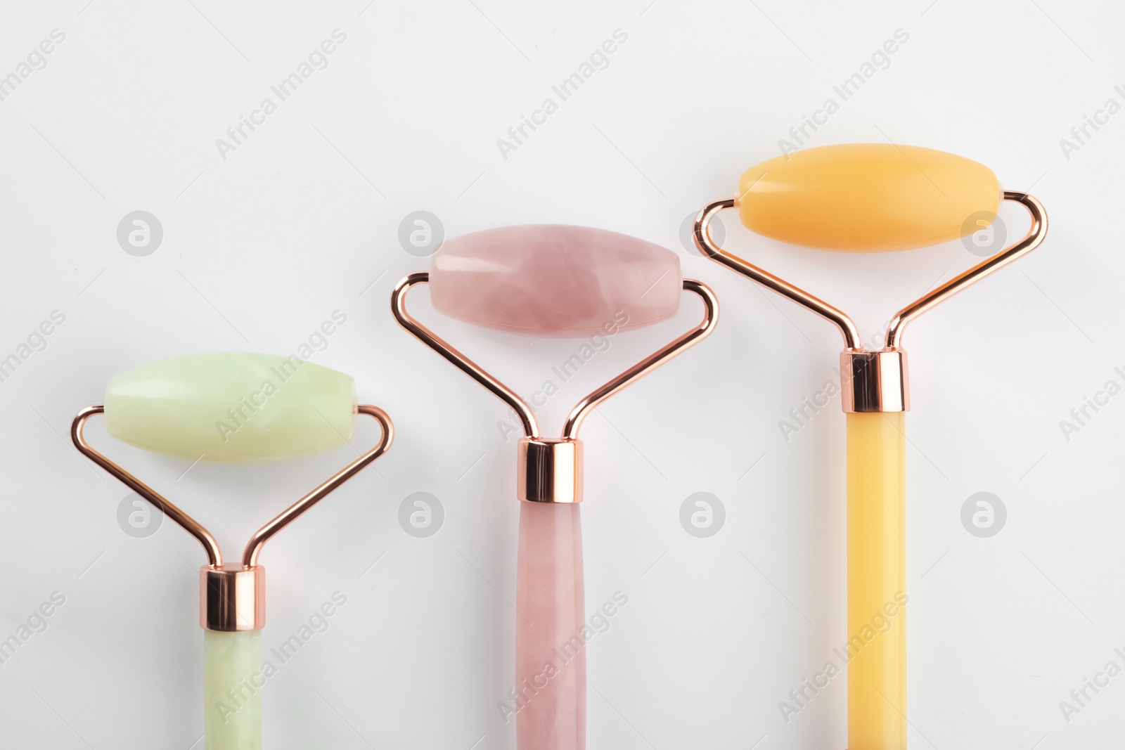 Photo of Different natural face rollers on white background, top view