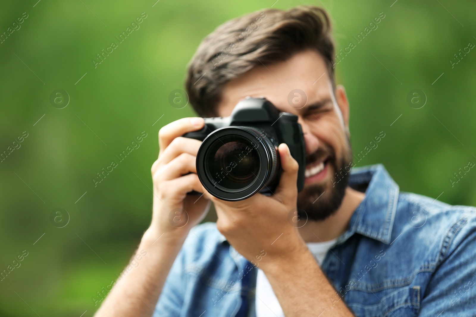 Photo of Photographer taking photo with professional camera in park