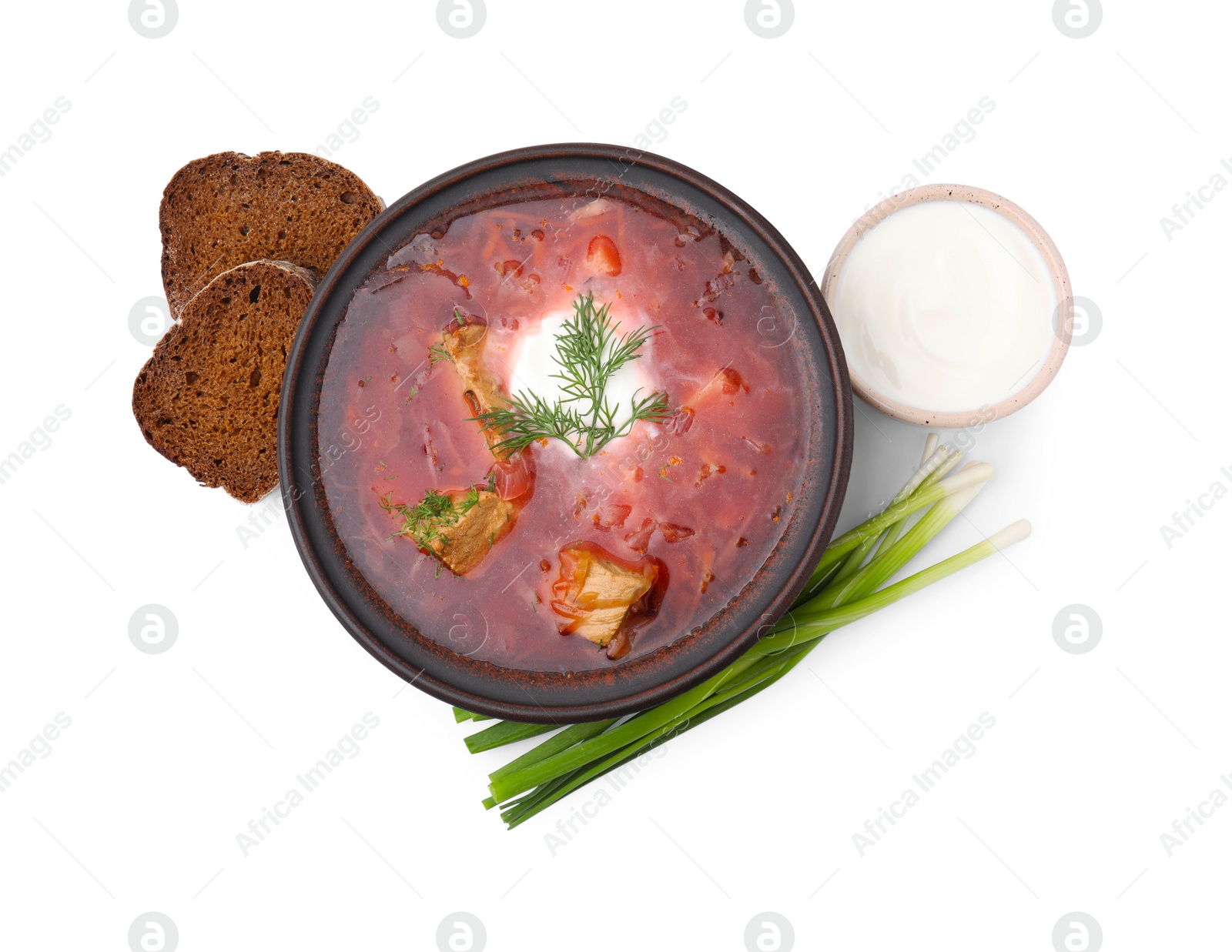 Photo of Tasty borscht with sour cream, green onion and bread isolated on white, top view