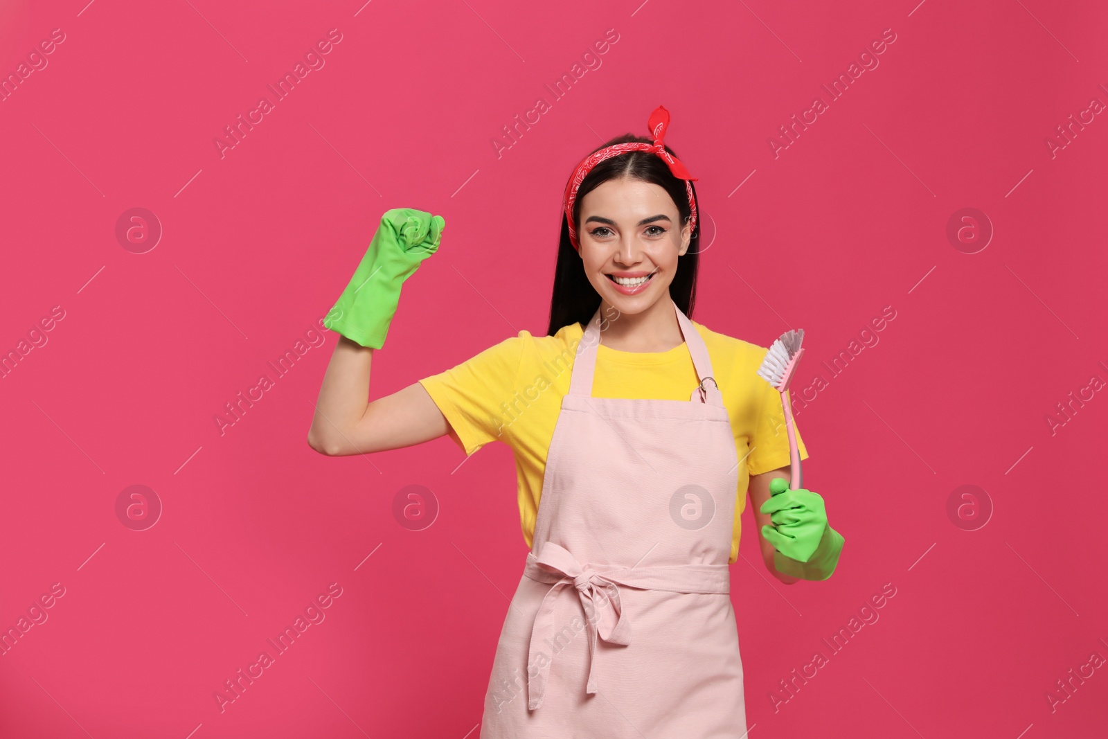 Photo of Young housewife with brush on pink background