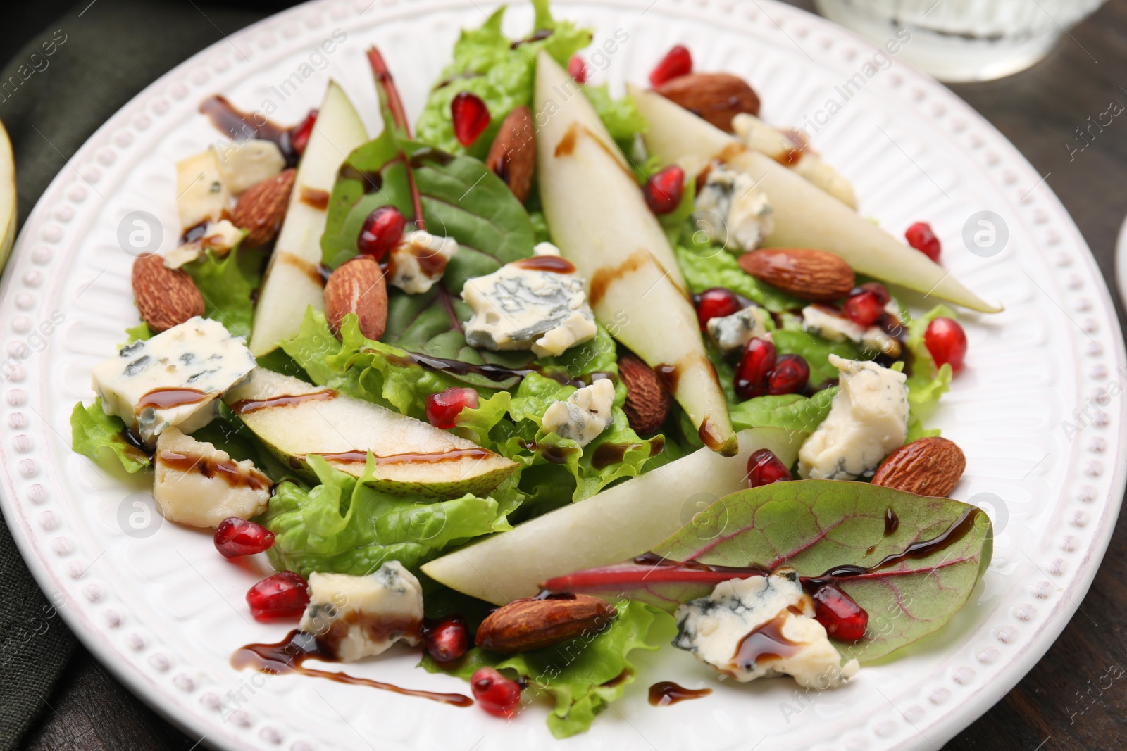 Photo of Delicious pear salad with sauce on wooden table, closeup