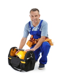 Electrician with tools wearing uniform on white background