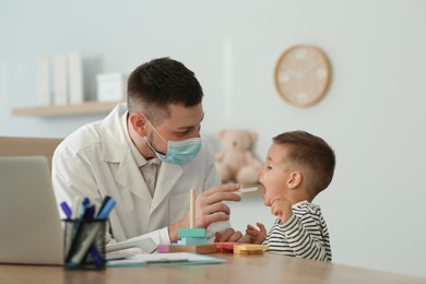 Photo of Pediatrician examining cute little boy at hospital