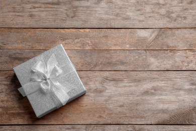 Beautiful gift box on wooden background, top view