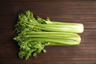 Photo of Fresh ripe green celery on wooden table, flat lay