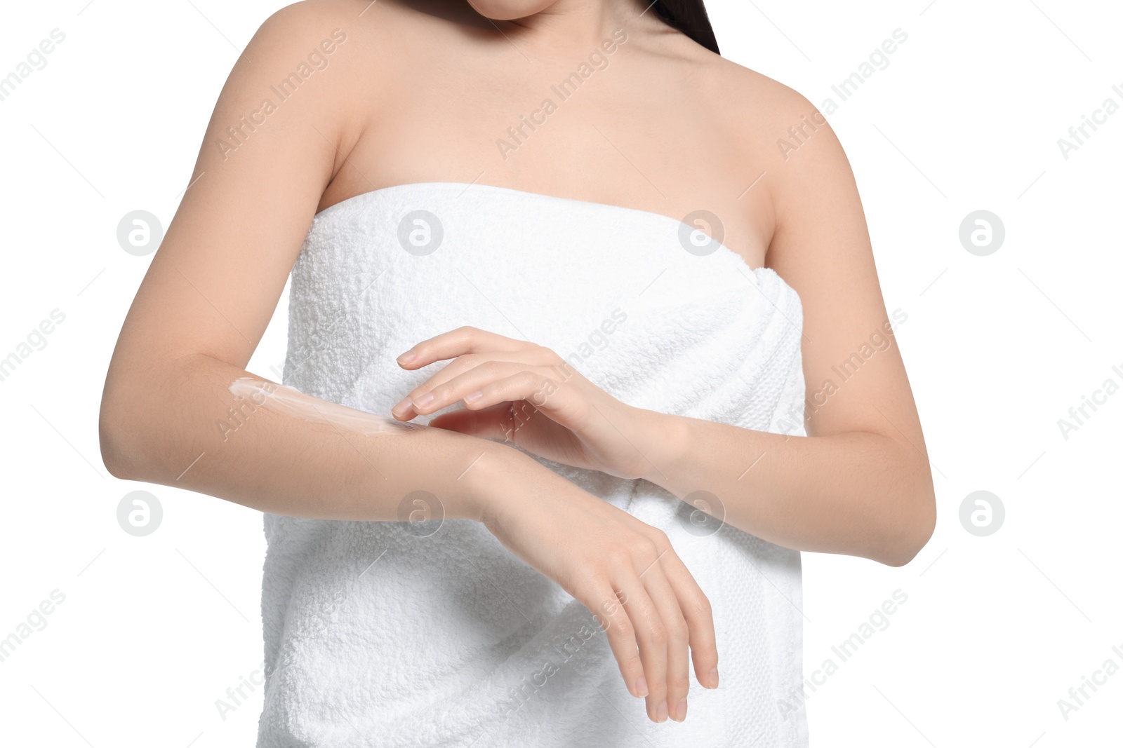 Photo of Young woman applying body cream onto arm on white background, closeup