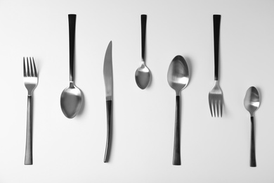 Photo of Set of new metal cutlery on white background, top view