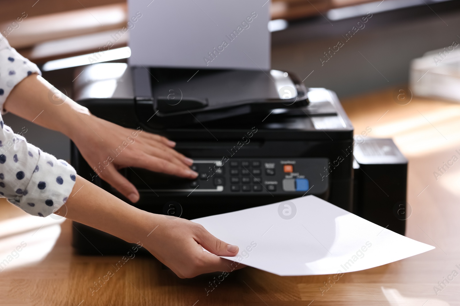 Photo of Employee using modern printer in office, closeup