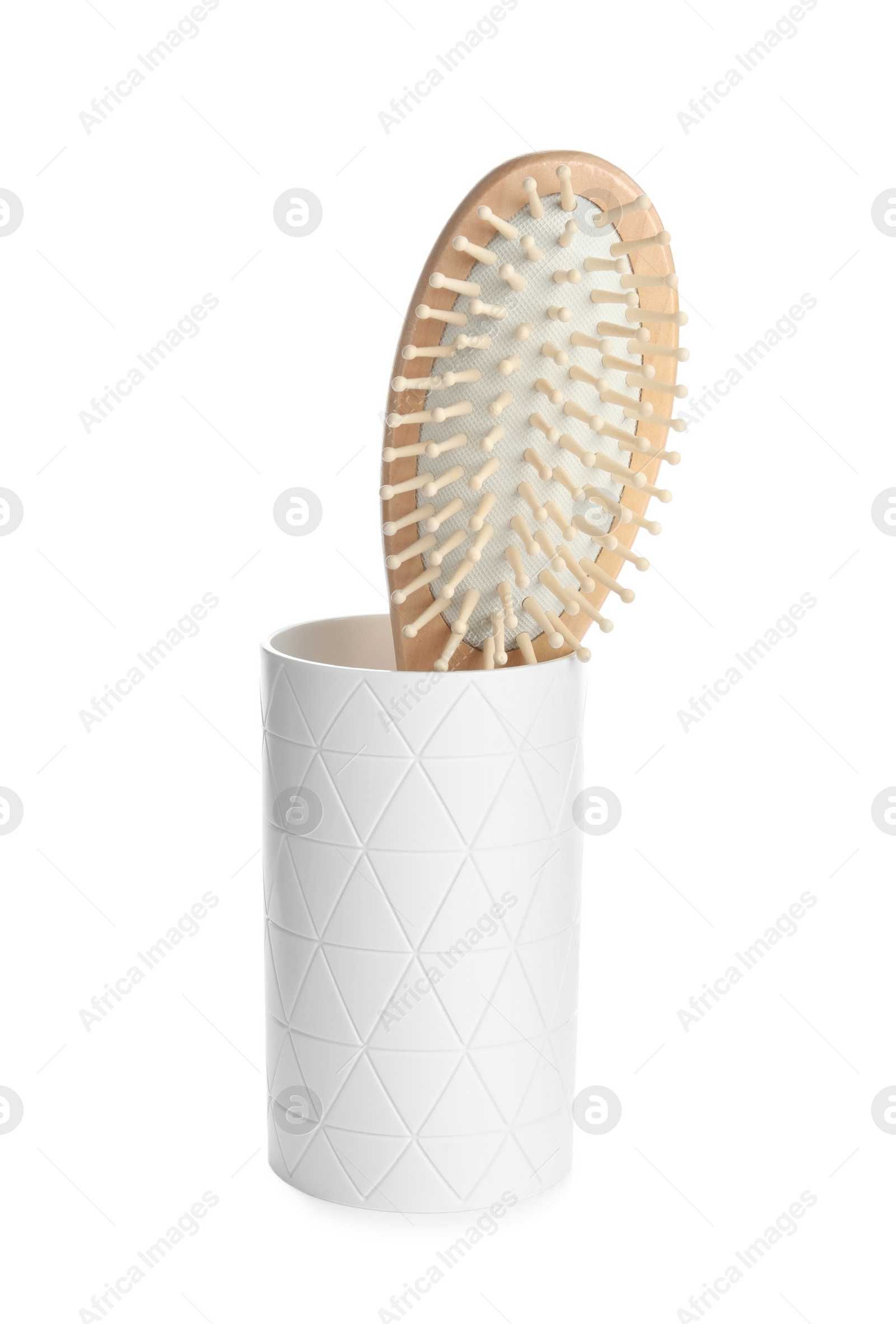 Photo of Wooden hair brush in ceramic holder isolated on white