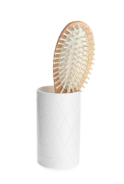 Photo of Wooden hair brush in ceramic holder isolated on white