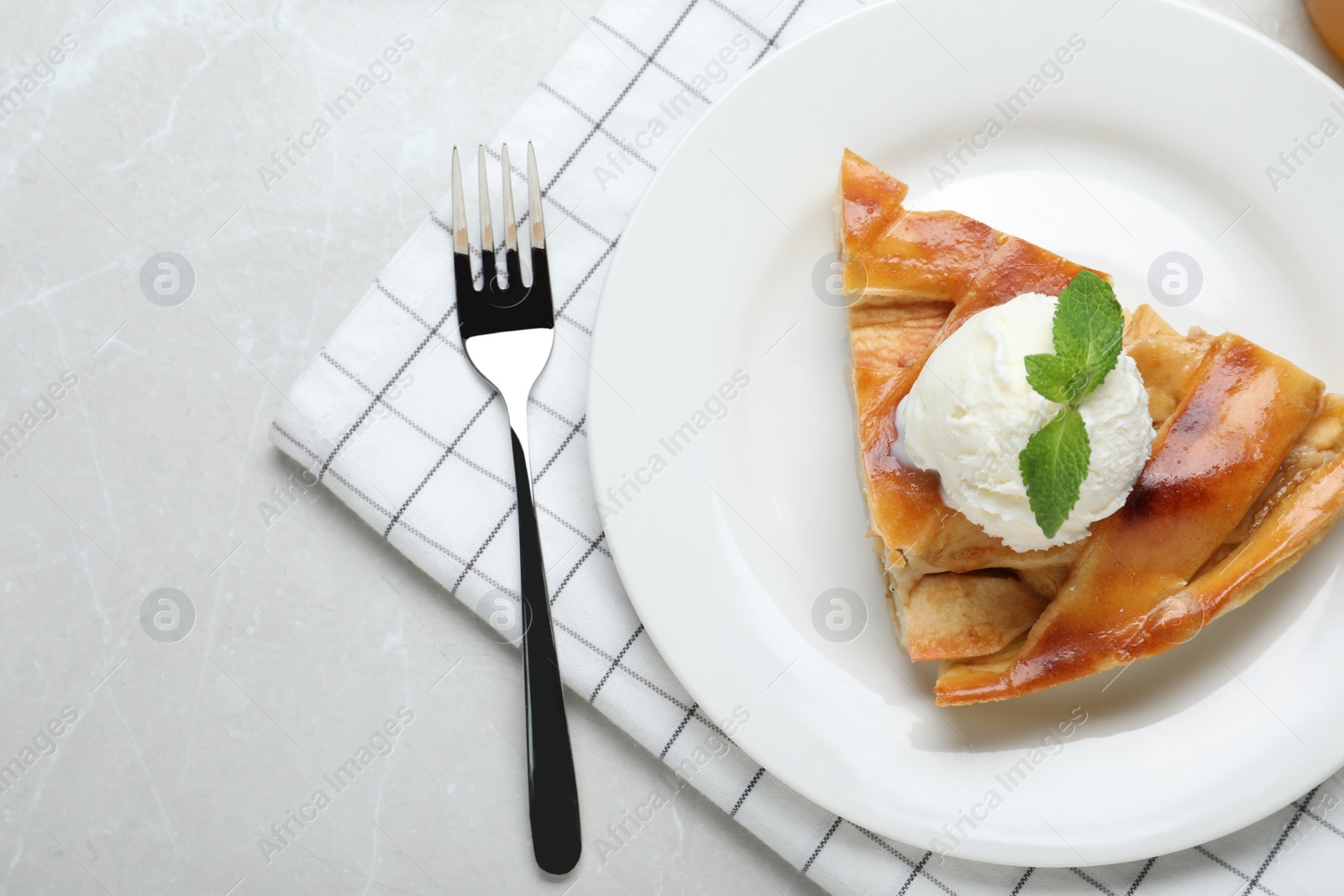 Photo of Slice of traditional apple pie with ice cream served on light marble table, flat lay