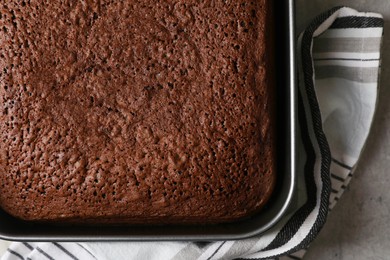 Homemade chocolate sponge cake on light grey table, top view