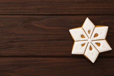 Photo of Snowflake shaped Christmas cookie on wooden table, top view. Space for text