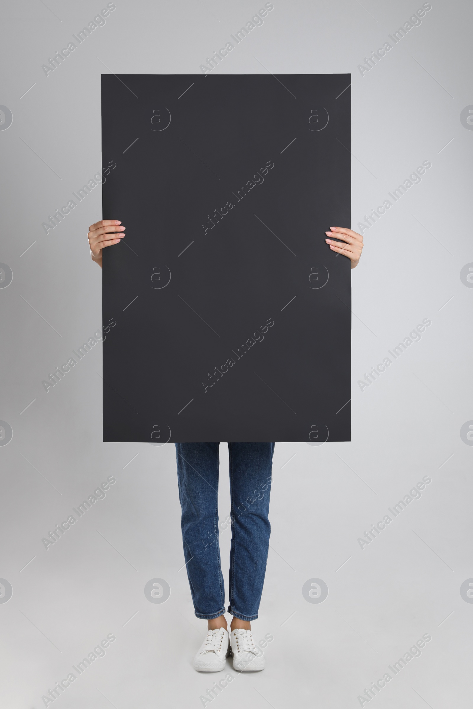 Photo of Woman holding blank poster on light grey background