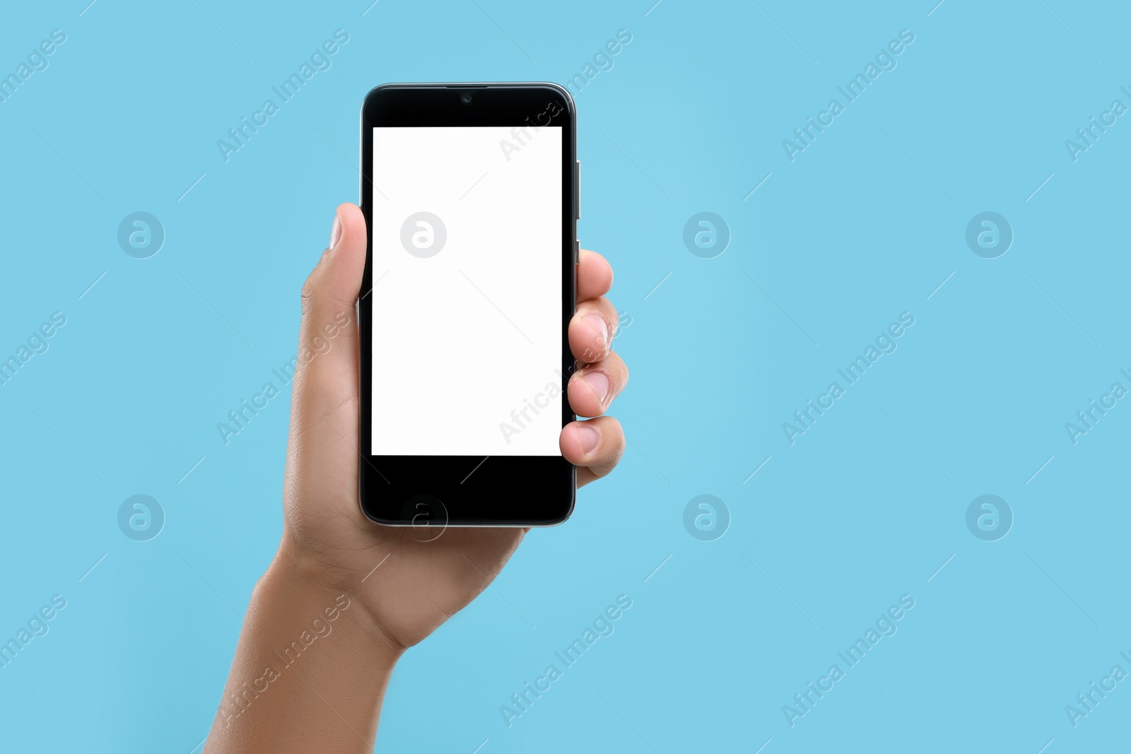 Photo of Man holding smartphone with blank screen on light blue background, closeup. Mockup for design