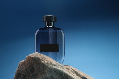 Photo of Stylish presentation of luxury men`s perfume on stone against light blue background. Space for text