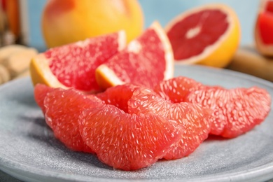 Photo of Ripe grapefruit on plate, closeup. Fresh fruit