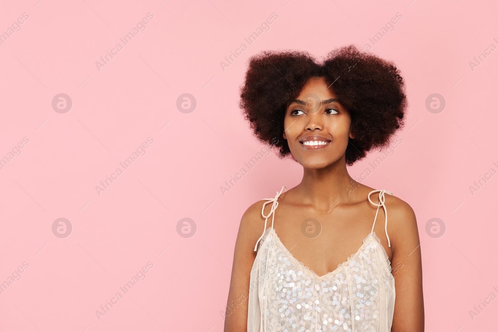 Photo of Portrait of smiling African American woman on pink background. Space for text