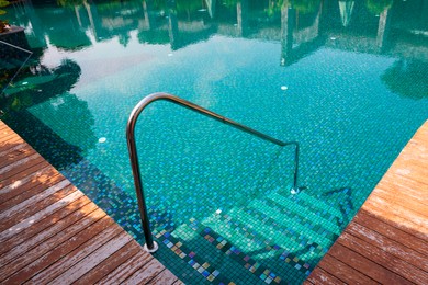 Outdoor swimming pool with steps and rail at resort