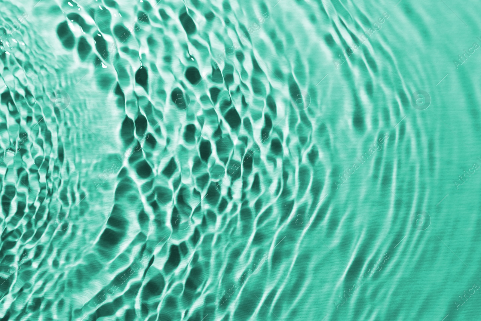 Image of Rippled surface of clear water on green background, closeup