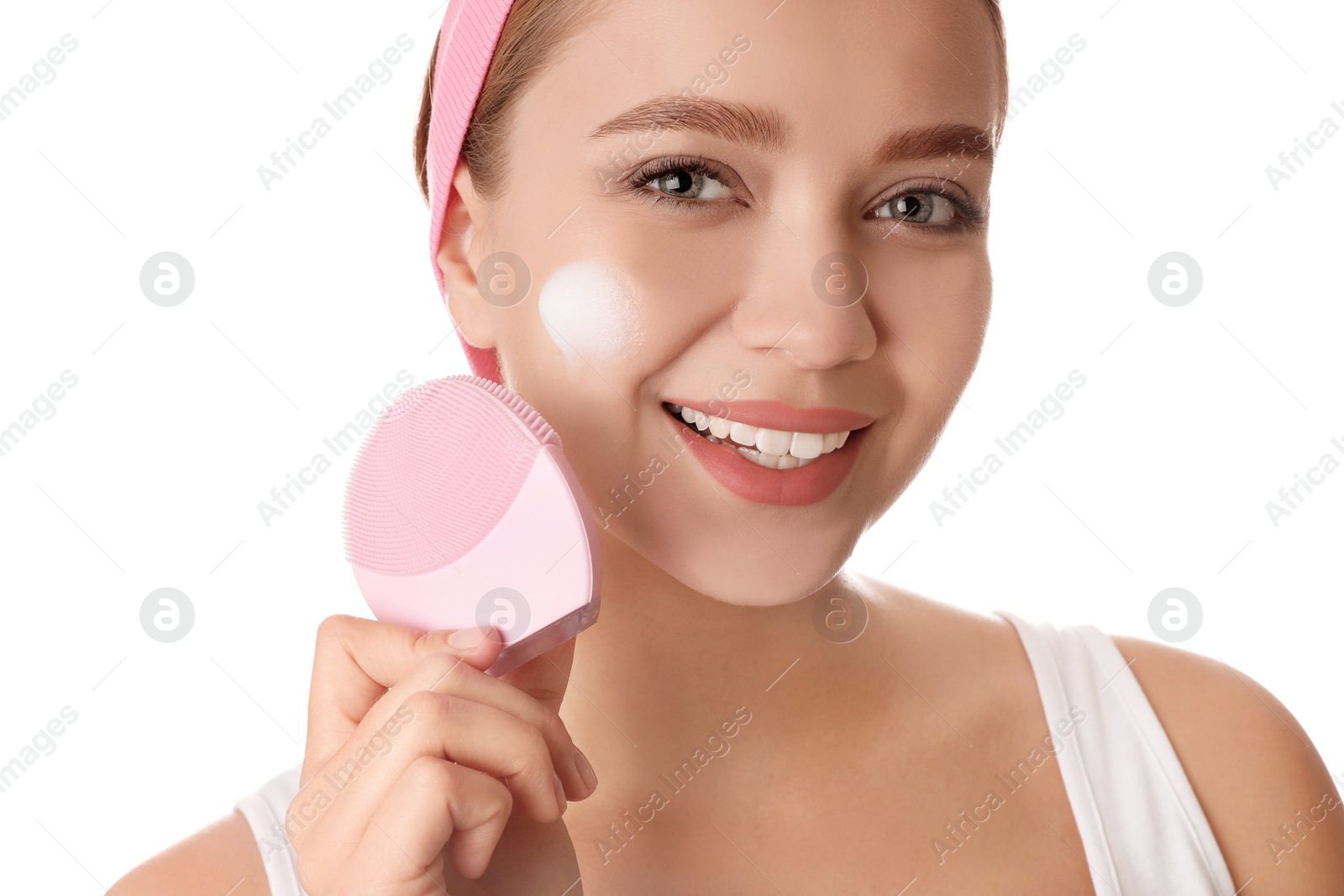 Photo of Young woman washing face with brush and cleansing foam on white background. Cosmetic products