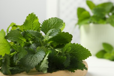 Fresh lemon balm on wooden table, closeup