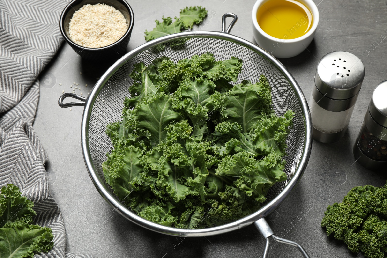 Photo of Raw cabbage leaves on grey table. Preparing kale chips