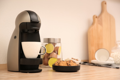 Photo of Modern coffeemaker on wooden countertop in kitchen