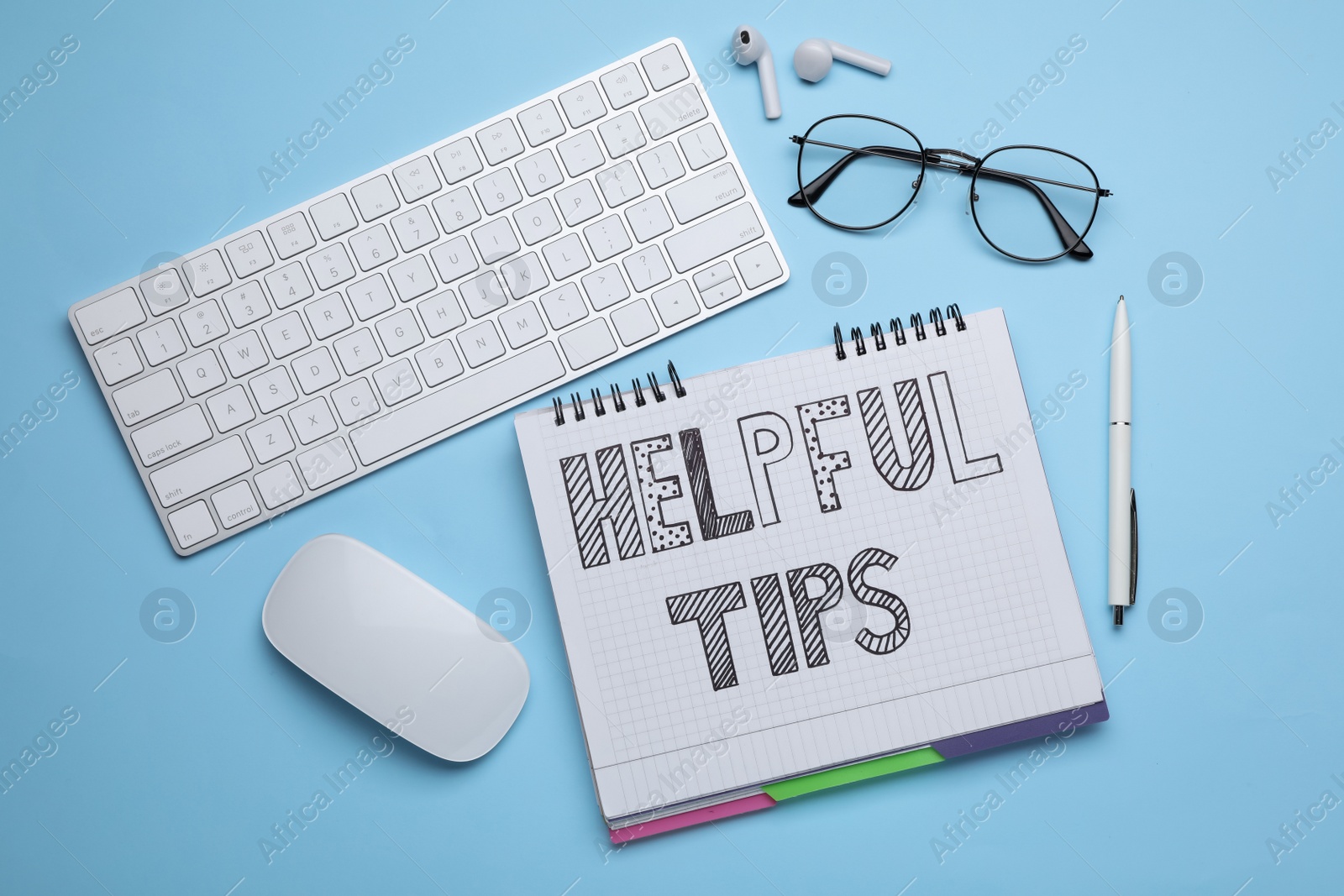 Photo of Helpful Tips. Flat lay composition with notebook and computer keyboard on light blue background