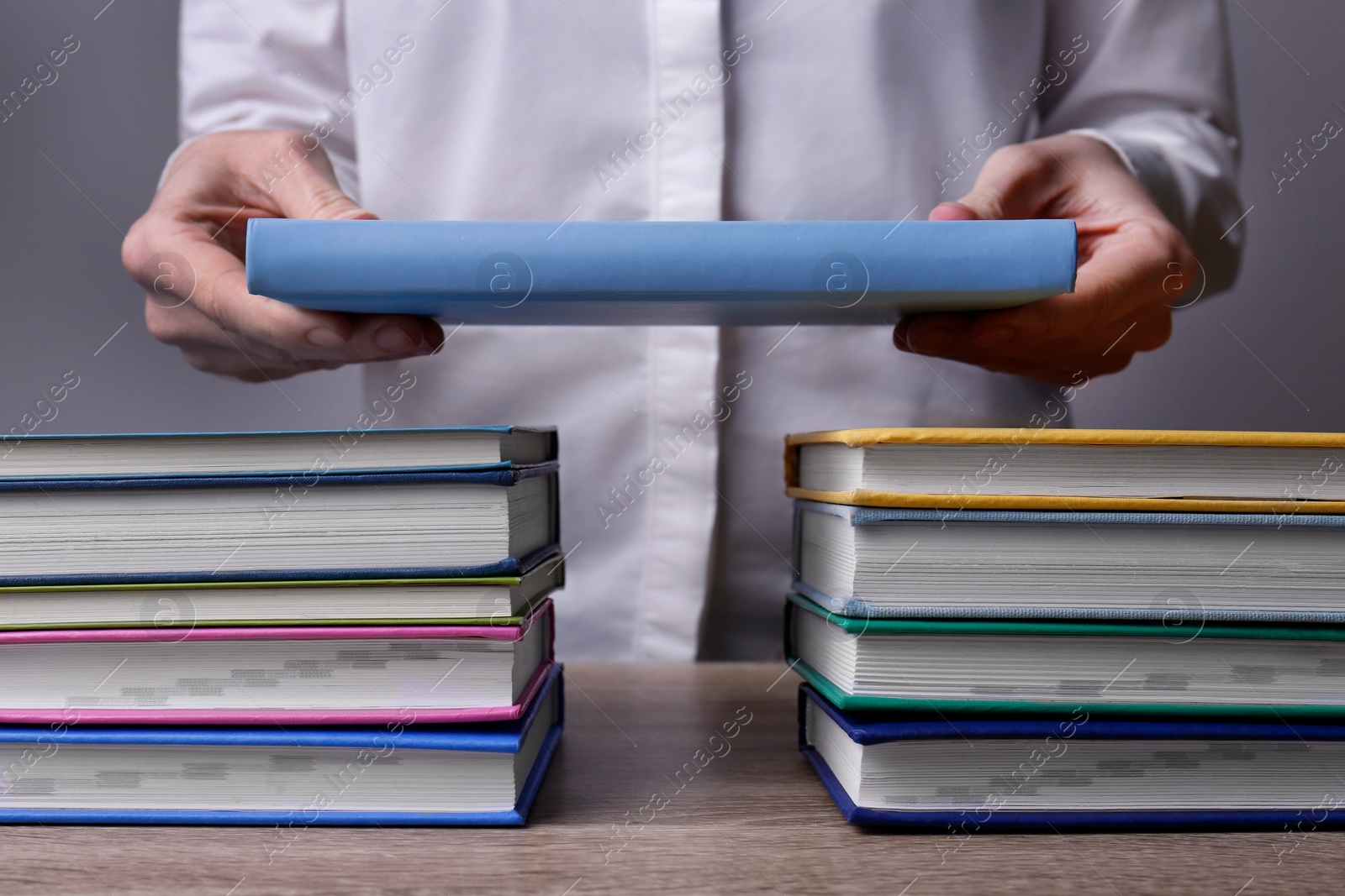 Photo of Woman building bridge with books at table, closeup. Connection, relationships and deal concept