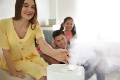 Photo of Family near modern air humidifier at home