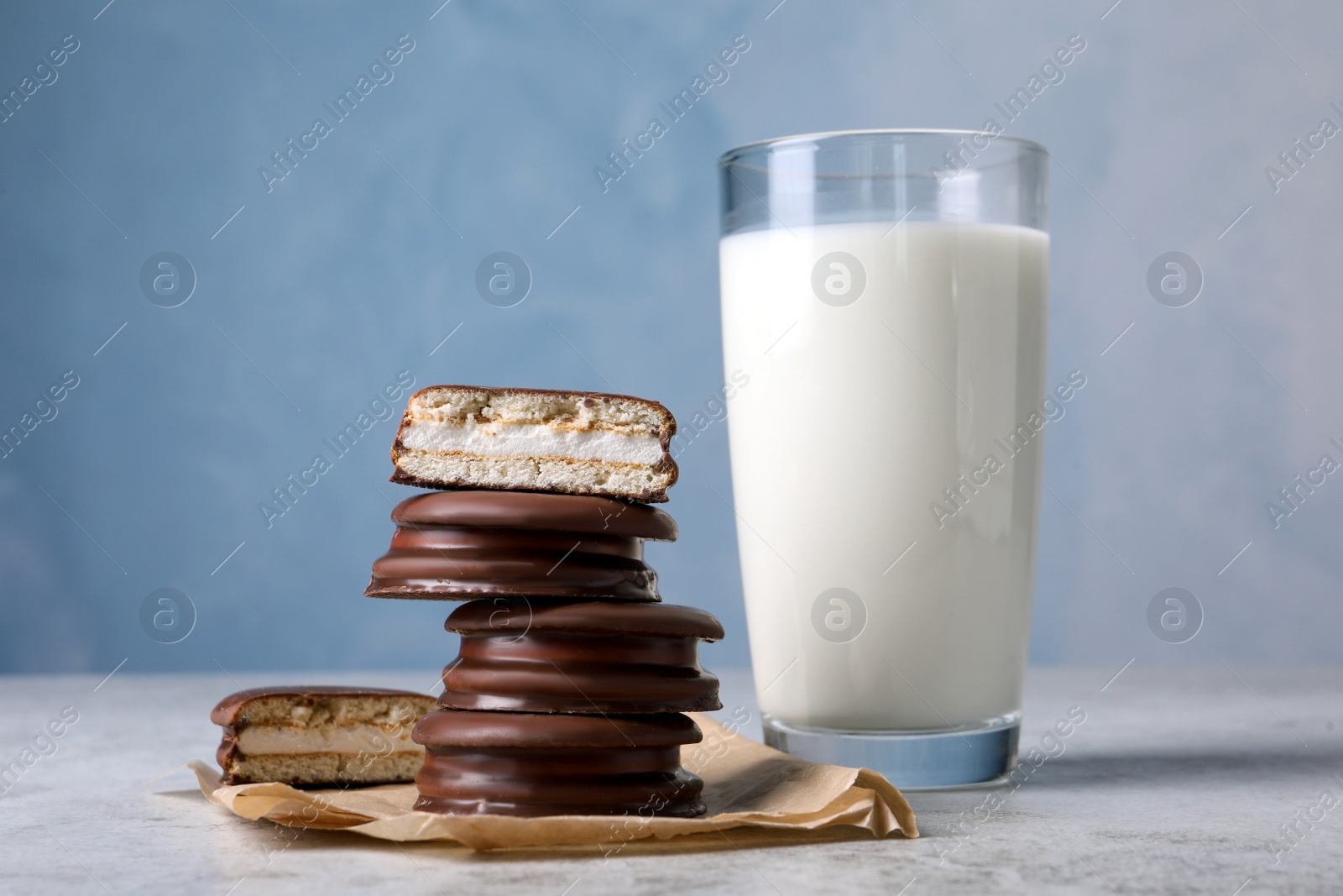 Photo of Tasty choco pies and milk on grey table