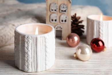 Composition with candle in ornate holder on white table. Christmas decoration