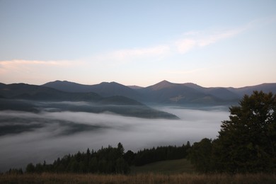 Picturesque view of mountains covered with fog in morning